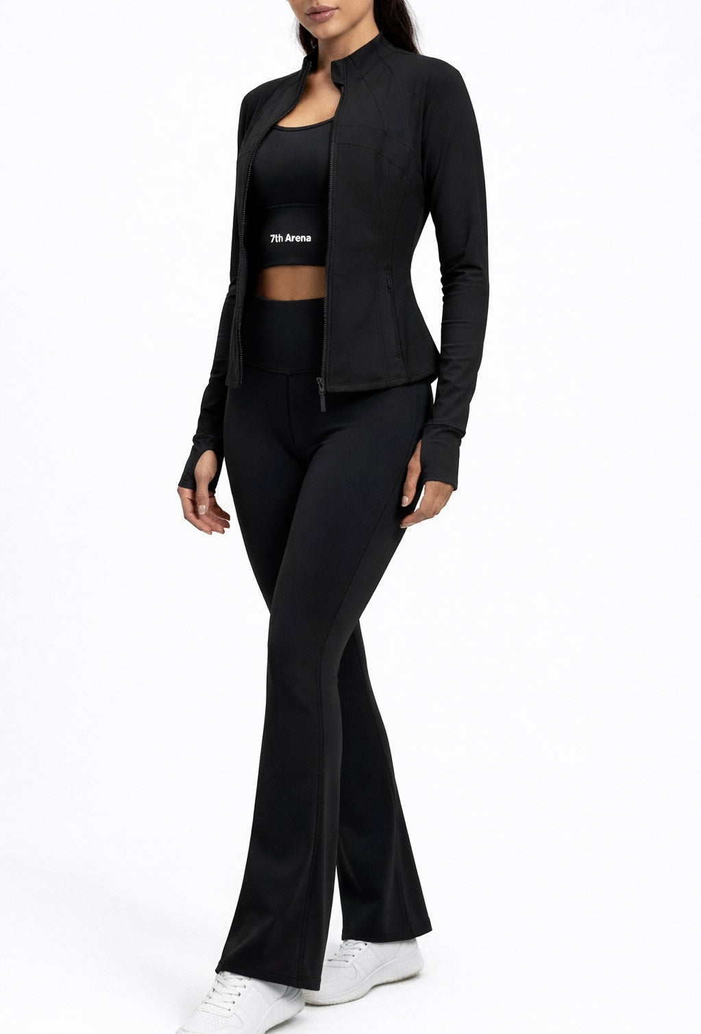 Person wearing a black athletic outfit with a jacket, sports bra and leggings on a white background