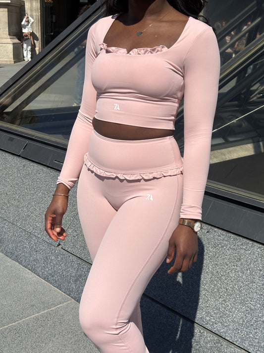 Person wearing light pink leggings and top in an urban setting