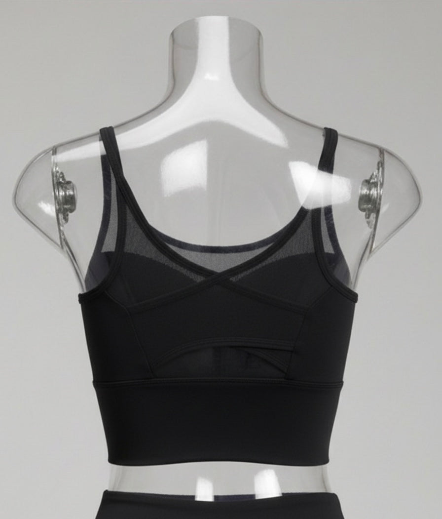 Black sports bra on a mannequin with sheer mesh panels against a gray background