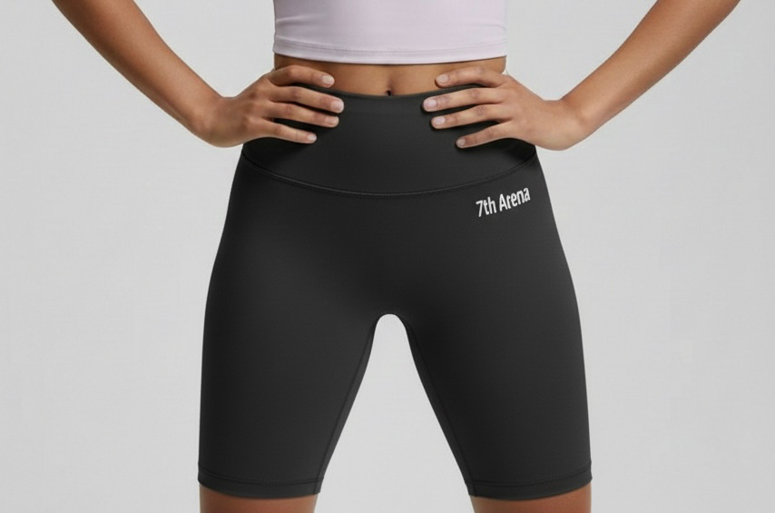 Person wearing black athletic shorts with '7th Arena' logo on a gray background