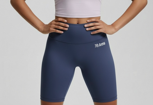 Person wearing navy blue athletic shorts with '7th Arena' branding on a gray background