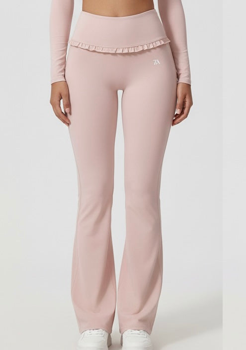 Person wearing light pink flare leggings with a subtle pattern on a white background