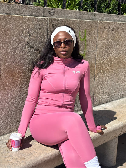 Person in pink athletic outfit sitting outdoors 